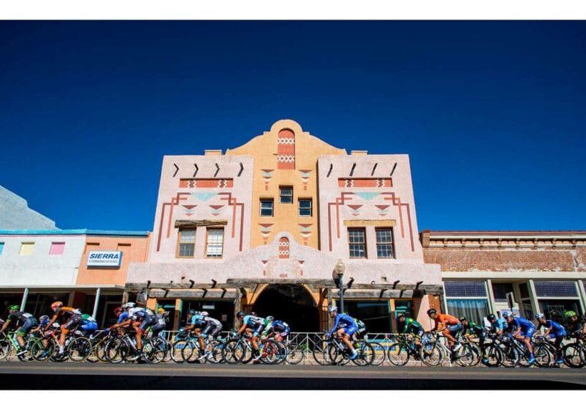 A group of people riding bikes in front of a building.